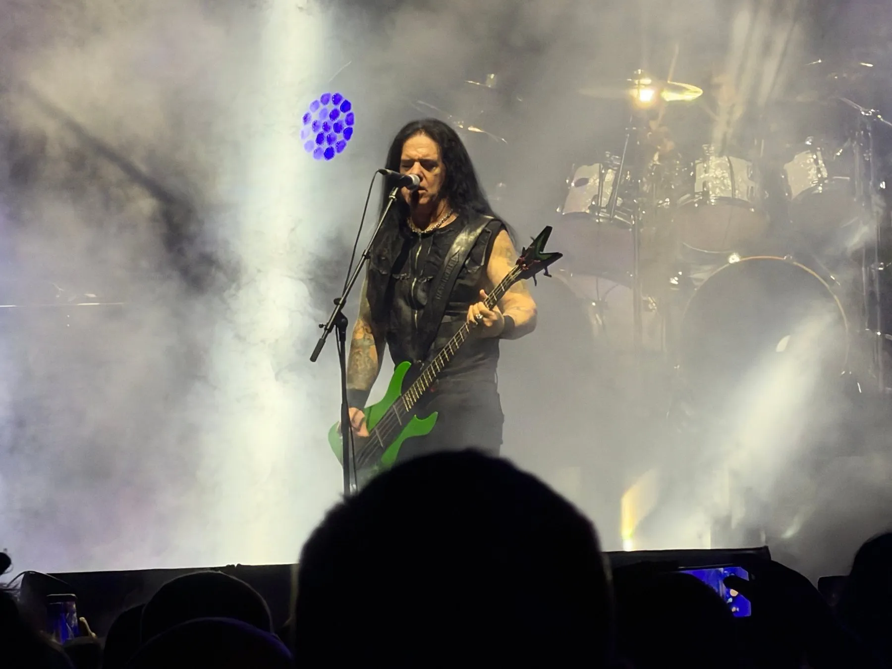 I Am Morbid's singer playing a green guitar amid smoke and white lights