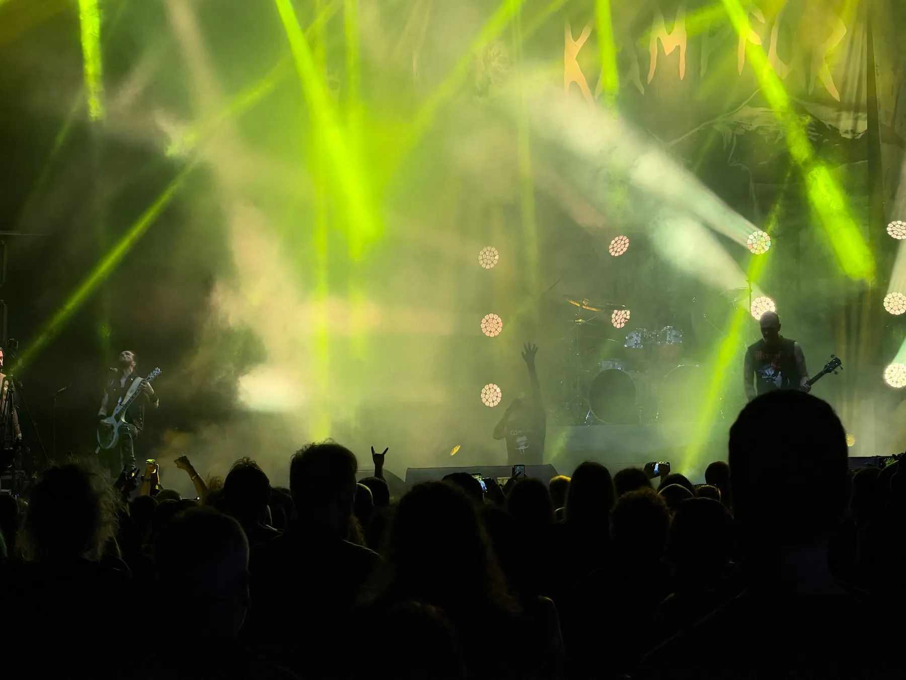 Kampfar on stage in green light and smoke, with the crowd in front