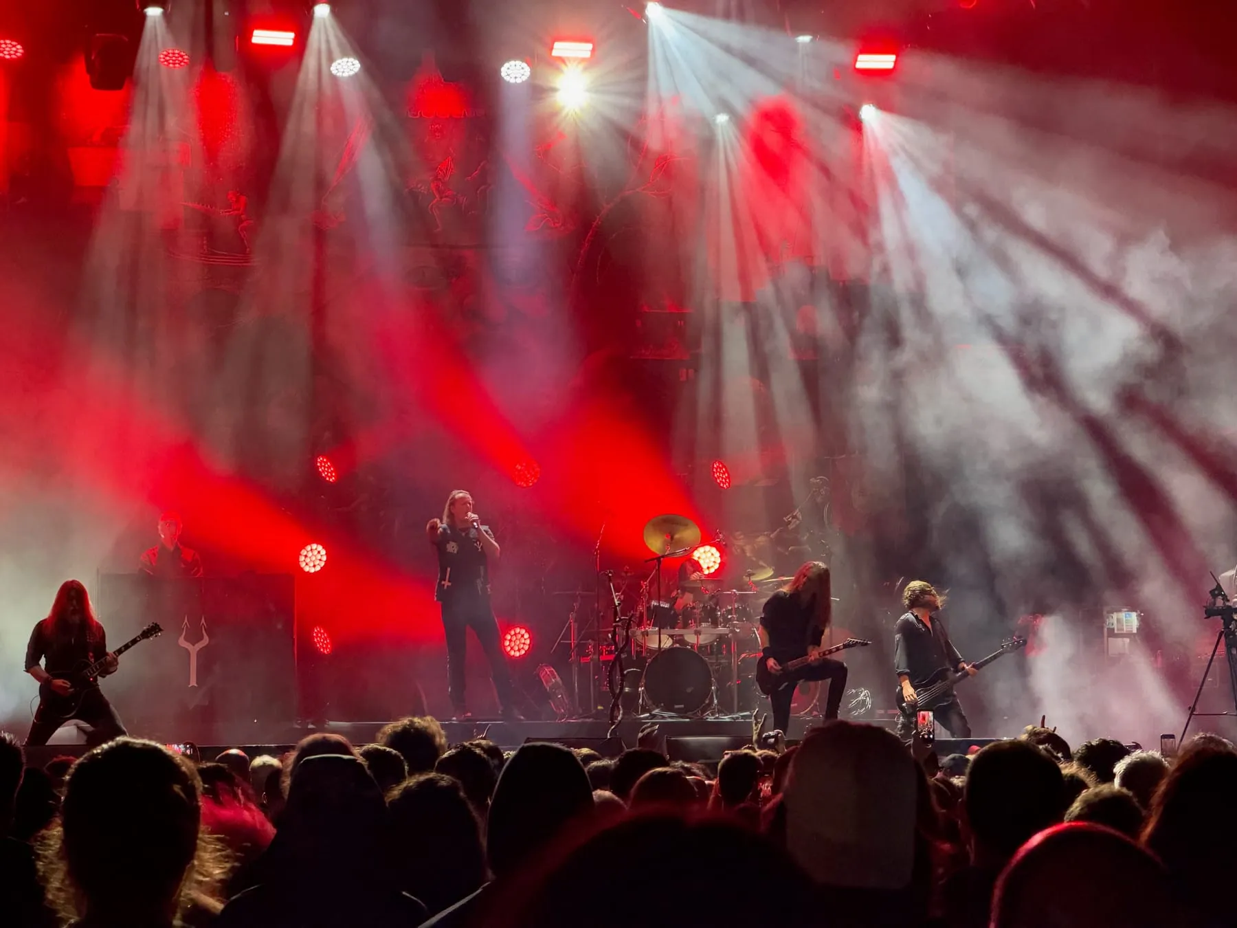 Satyricon performing beneath red and white stage lights